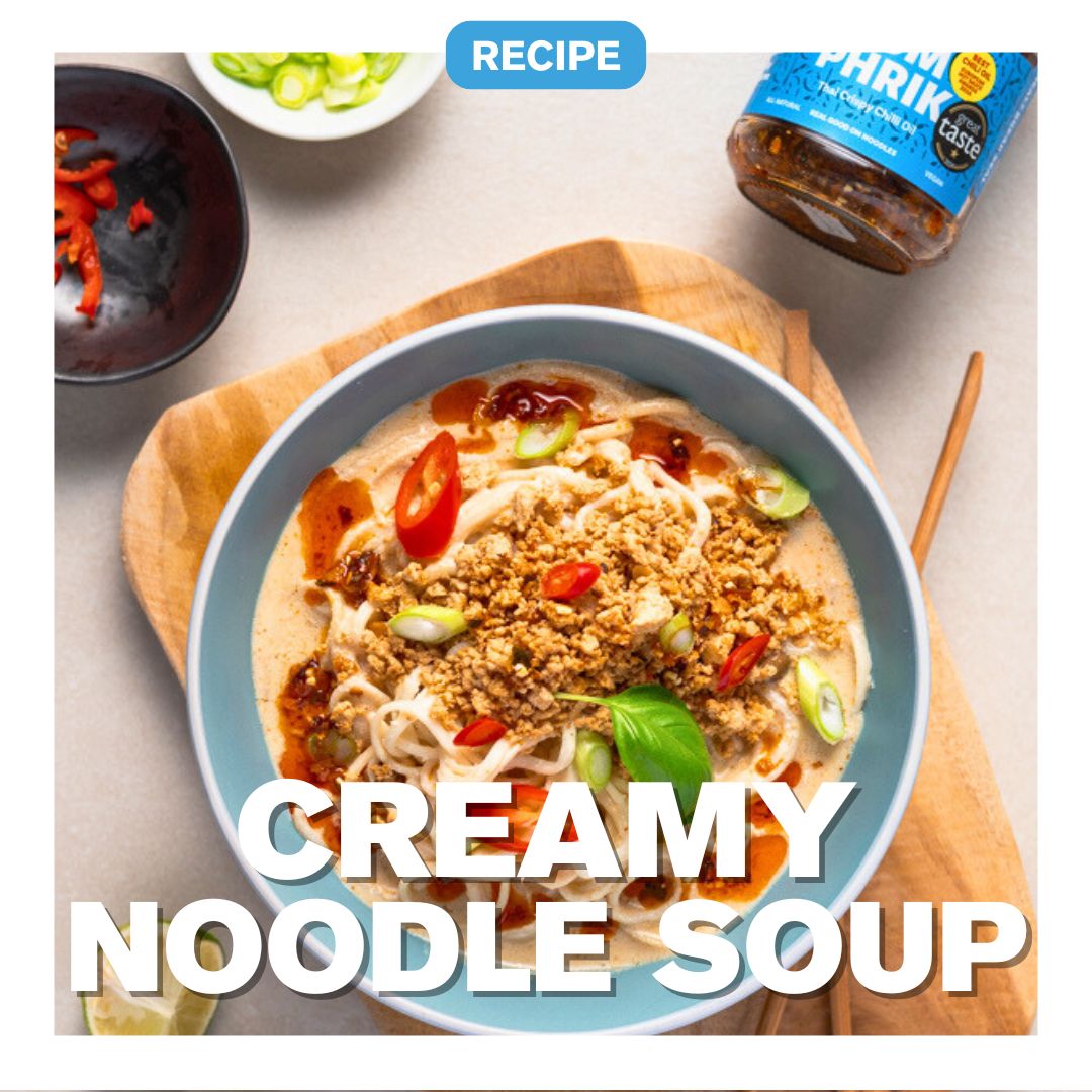 Creamy noodle soup with crispy chilli oil, scallions, and Thai - Yum Phrik chili olie jar in the background.
