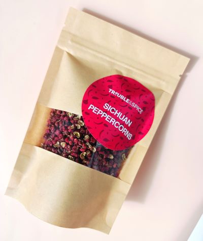 Brown paper pouch of Sichuan peppercorns from Trouble & Spice, whole dried peppers used for Chinese cooking and spicy dishes.