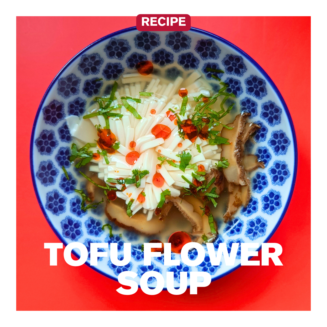 Tofu Flower Soup with mushrooms, herbs, and chilli oil - chili olie in a blue bowl.