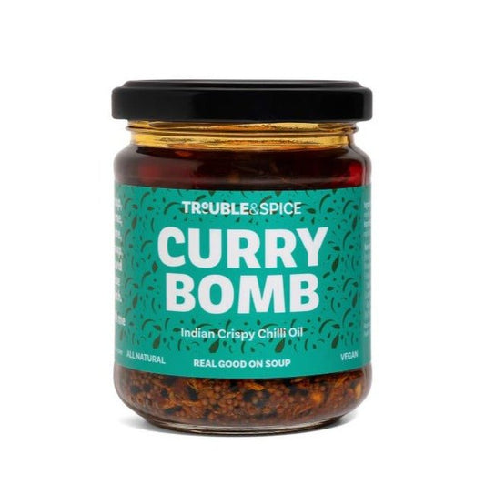 Jar of Trouble & Spice Curry Bomb, an Indian crispy chilli oil (chii olie) with a teal label and black lid.